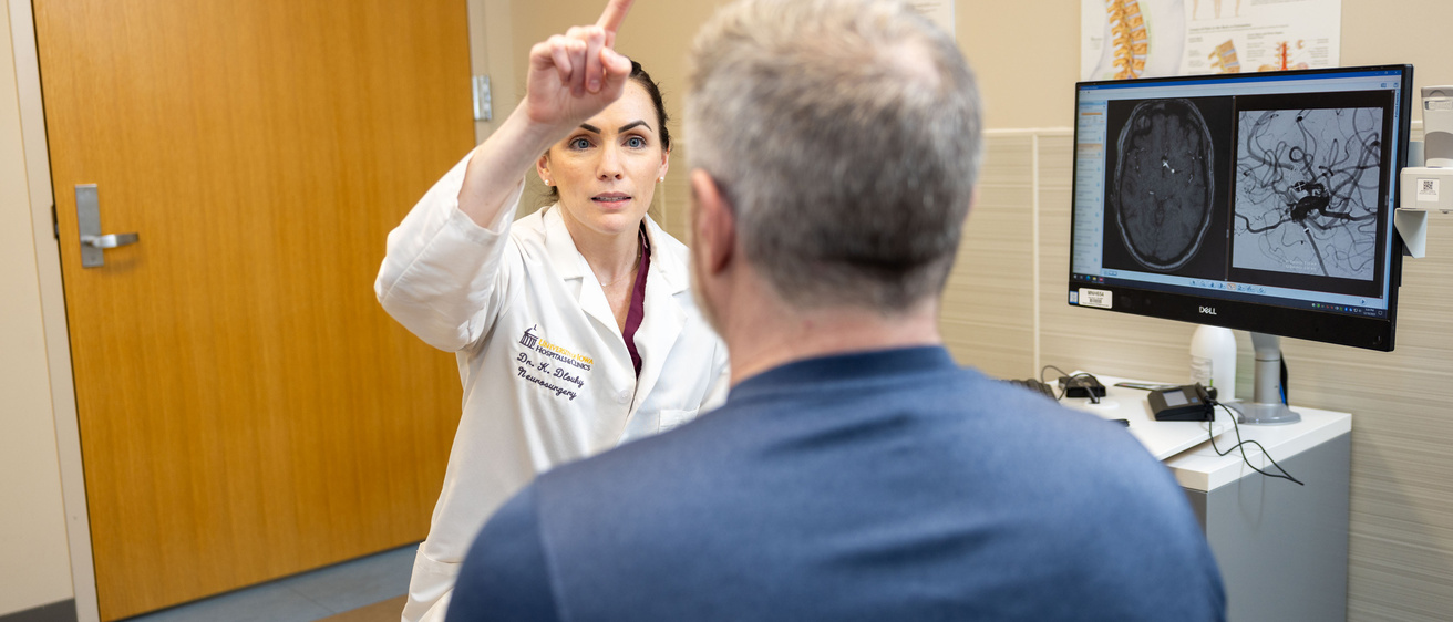 Kathleen Dlouhy in the neurosurgery clinic with simulated patients (employees) on Monday, Dec. 18, 2023. Patient information has been blurred.