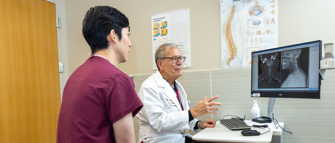 Patrick Hitchon with Brian Park, neurosurgery resident PGY-7, in the neurosurgery clinic with simulated patients (employees) on Monday, Dec. 18, 2023. Patient information has been blurred.